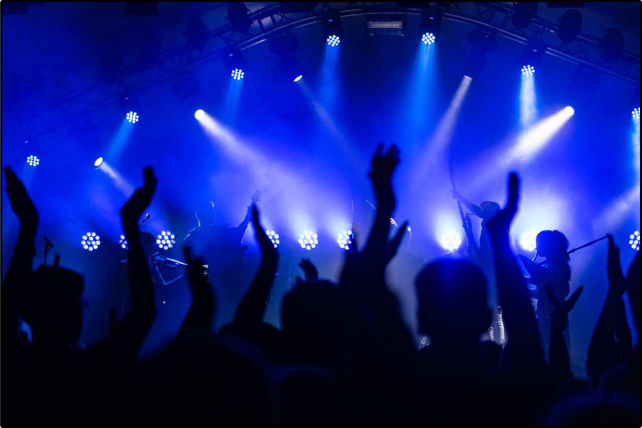 Crowd cheering as the band performs their hit songs at a packed concert venue